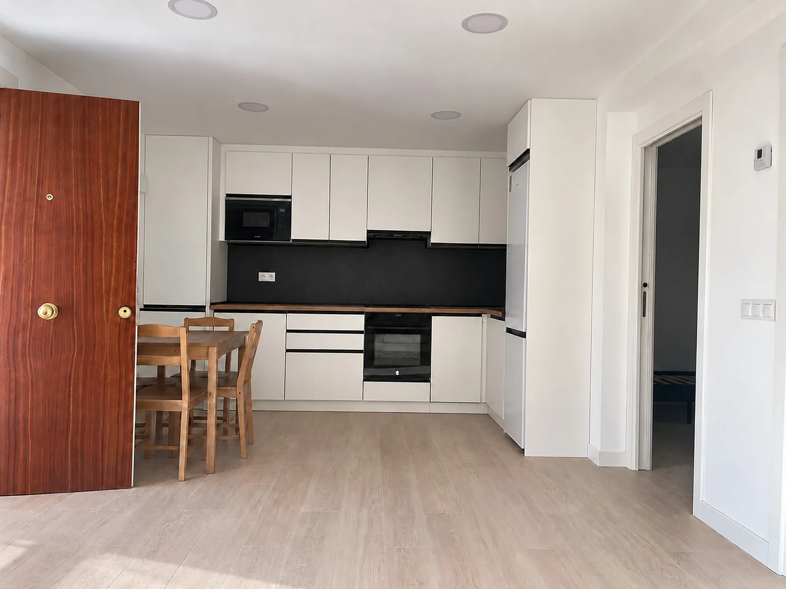 Salón y cocina abiertos, vistos desde la entrada.